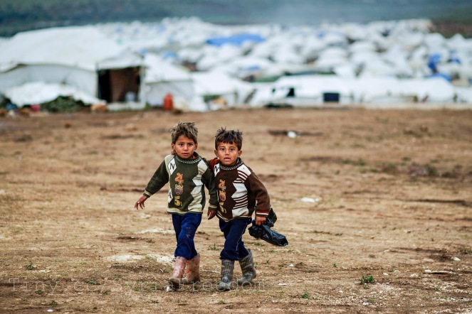 Syrian boys, whose family fled their home in Idlib, walk to their tent, at a camp for displaced Syrians, in the village of Atmeh, Syria. Picture: Flickr/ Freedom House